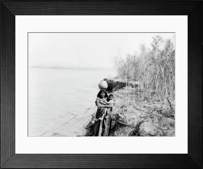 Framed Print : Mohave woman carrying water on her head and holding child, c1903. Creator: Edward Sheriff Curtis Framed Print : Mohave woman carrying water on her head and holding child, c1903. Creator: Edward Sheriff Curtis