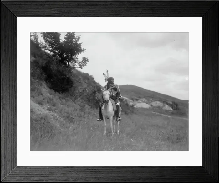 Framed Print : Sioux Indian on horseback, wearing two feathers, beaded buckskin shirt, and leggings... c1907. Creator: Edward Sheriff Curtis Framed Print : Sioux Indian on horseback, wearing two feathers, beaded buckskin shirt, and leggings... c1907. Creator: Edward Sheriff Curtis