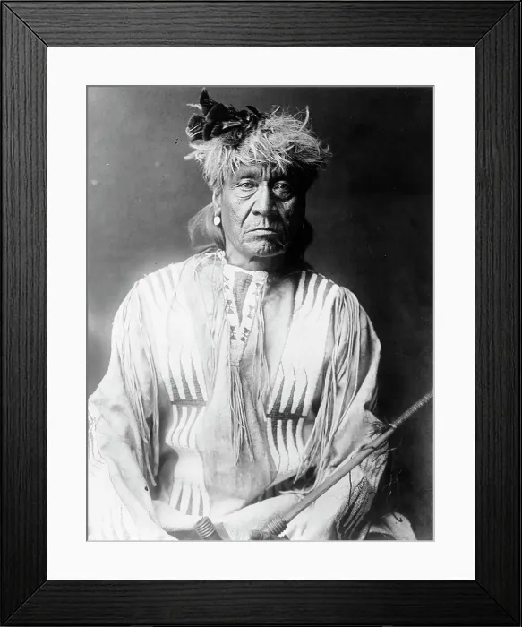 Framed Print : Atsina Indian, Red Whip, half-length portrait, seated, facing front, wearing feather... c1908. Creator: Edward Sheriff Curtis Framed Print : Atsina Indian, Red Whip, half-length portrait, seated, facing front, wearing feather... c1908. Creator: Edward Sheriff Curtis
