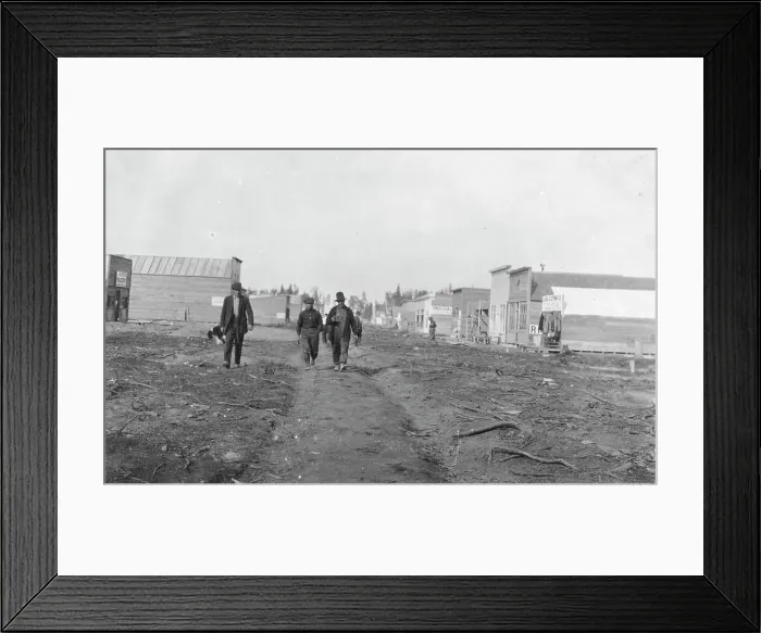 Framed Print : Three men walking down a dirt road, through town, between c1900 and 1916. Creator: Unknown Framed Print : Three men walking down a dirt road, through town, between c1900 and 1916. Creator: Unknown