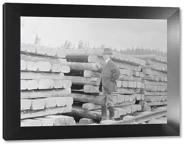 Frank G. Carpenter standing by railroad ties, between c1900 and 1916. Creator: Unknown