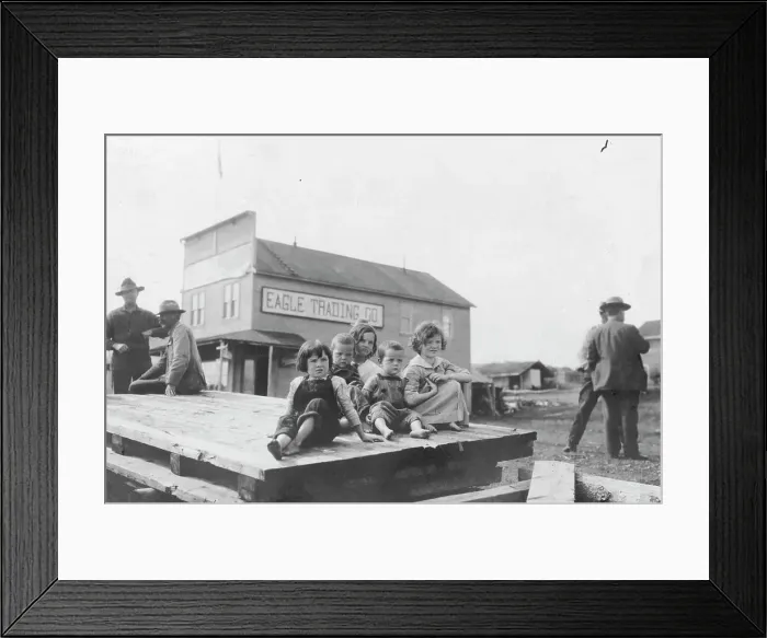 Framed Print : Children outside Eagle Trading Company, between c1900 and 1916. Creator: Unknown