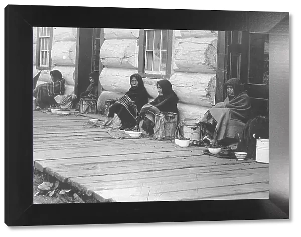 Indians sitting with backs to wall selling berries, between c1900 and c1930. Creator: Unknown