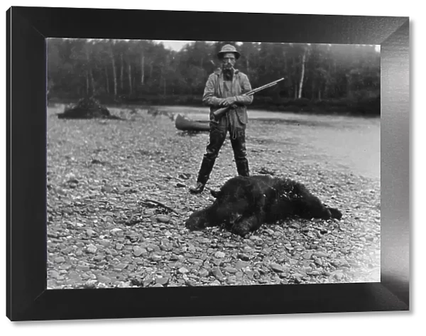 Hunter with bear which he killed, between c1900 and 1927. Creator: Unknown