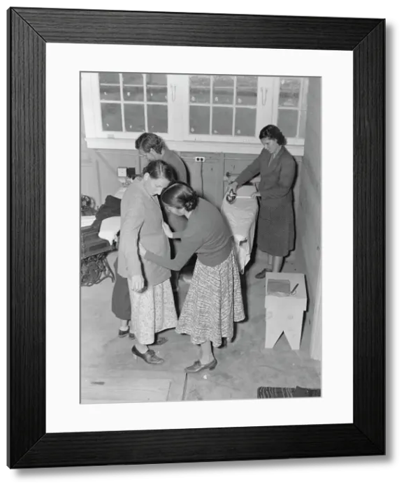 Framed Print : Camper receives help in fitting a coat from WPA sewing instructor, FSA, California, 1938. Creator: Dorothea Lange Framed Print : Camper receives help in fitting a coat from WPA sewing instructor, FSA, California, 1938. Creator: Dorothea Lange