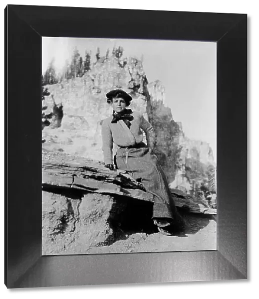 Frances Benjamin Johnston, full-length portrait, seated on rock in Yellowstone National Park, 1903. Creator: Frances Benjamin Johnston