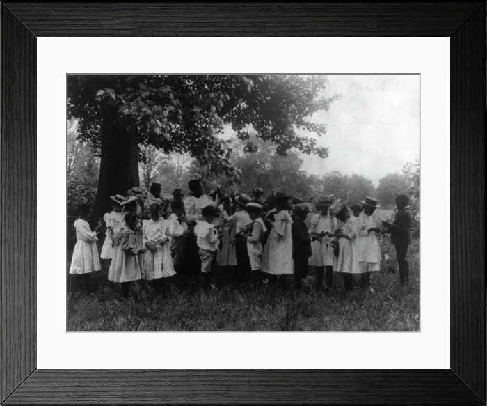 Framed Print : African American school children and teacher, studying leaves out of doors, (1899?). Creator: Frances Benjamin Johnston Framed Print : African American school children and teacher, studying leaves out of doors, (1899?). Creator: Frances Benjamin Johnston