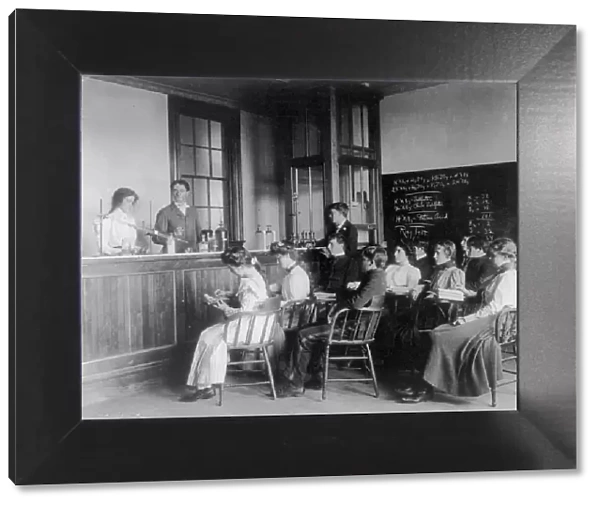 Students in a chemistry class observing others conducting an experiment...Washington DC, (1899?). Creator: Frances Benjamin Johnston