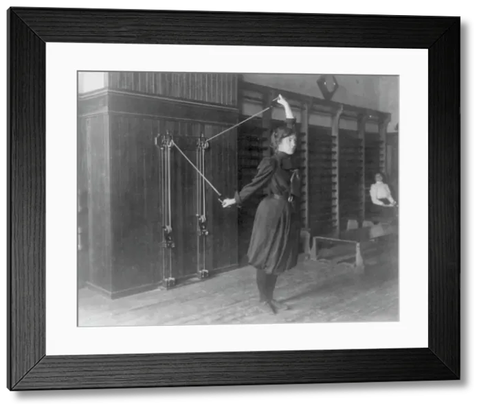 Framed Print : Female student exercising with a wall-mounted device using ropes and... Washington, DC, (1899?). Creator: Frances Benjamin Johnston Framed Print : Female student exercising with a wall-mounted device using ropes and... Washington, DC, (1899?). Creator: Frances Benjamin Johnston