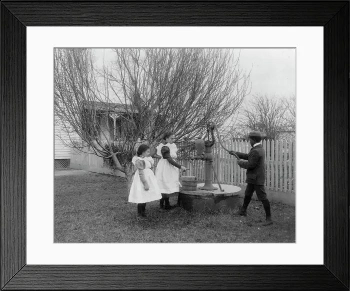 Framed Print : Two girls and a boy pumping water at well of Hampton Institute graduate, 1899 or 1900. Creator: Frances Benjamin Johnston Framed Print : Two girls and a boy pumping water at well of Hampton Institute graduate, 1899 or 1900. Creator: Frances Benjamin Johnston
