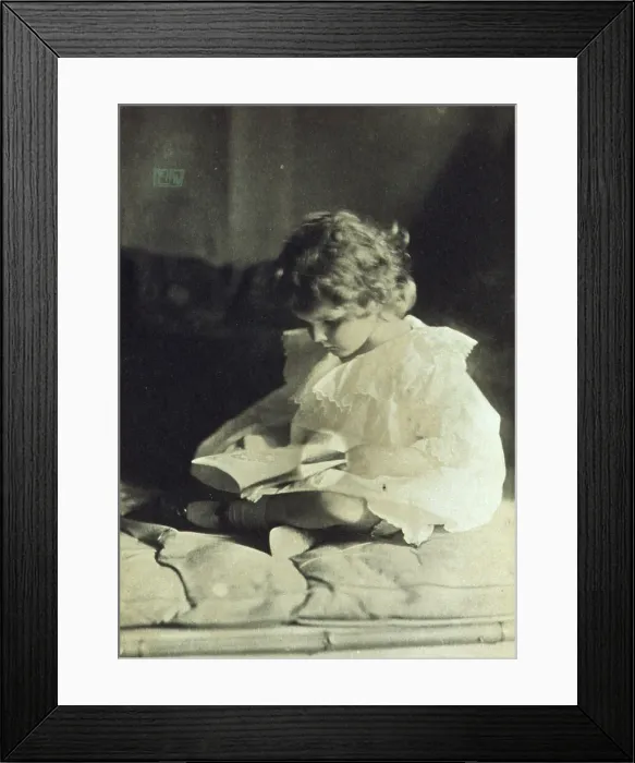 Framed Print : Girl sitting with legs folded, reading a book, c1900. Creator: Eva Watson-Schutze Framed Print : Girl sitting with legs folded, reading a book, c1900. Creator: Eva Watson-Schutze