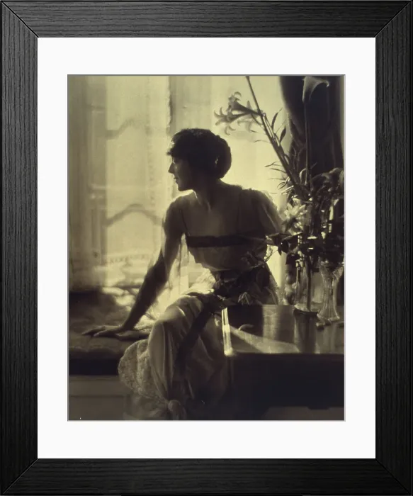 Framed Print : Woman sitting on window seat, looking left, full-length portrait, between 1900 and 1920. Creator: Unknown Framed Print : Woman sitting on window seat, looking left, full-length portrait, between 1900 and 1920. Creator: Unknown
