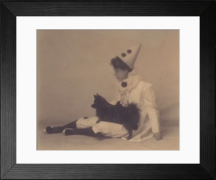 Framed Print : Girl dressed in a pierrot costume with a small black dog on her lap, between 1900 and 1920. Creator: Unknown Framed Print : Girl dressed in a pierrot costume with a small black dog on her lap, between 1900 and 1920. Creator: Unknown