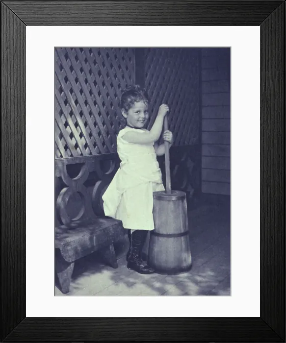 Framed Print : Little girl wearing white chemise, beaded necklace, and high-button shoes on porch with... c1900. Creator: Unknown Framed Print : Little girl wearing white chemise, beaded necklace, and high-button shoes on porch with... c1900. Creator: Unknown