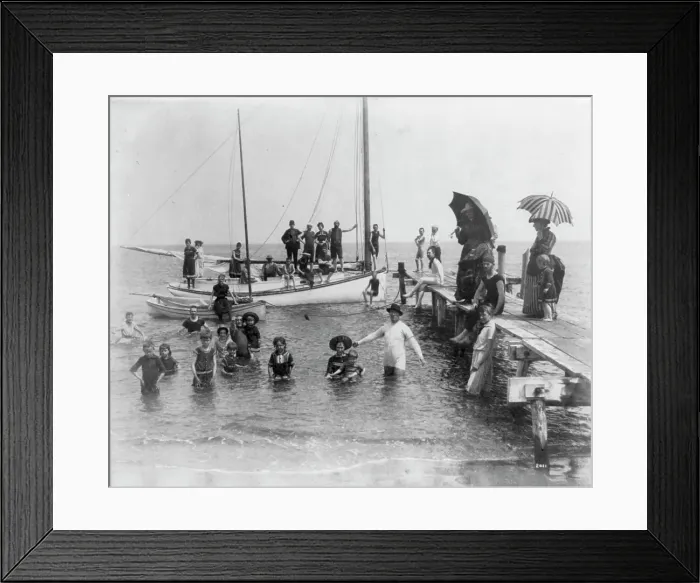 Framed Print : Men, women, and children in bathing suits on dock, sailboats, and in water... c1880. Creator: Unknown Framed Print : Men, women, and children in bathing suits on dock, sailboats, and in water... c1880. Creator: Unknown