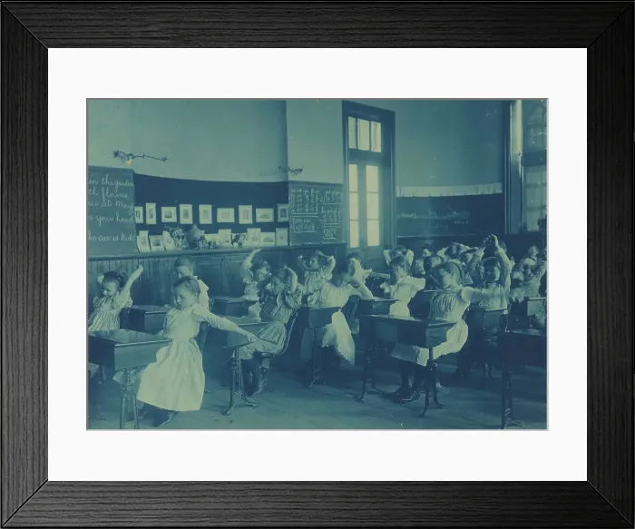 Framed Print : Children doing calisthenics while sitting at their desks in a classroom... Washington, DC, (1899?). Creator: Frances Benjamin Johnston Framed Print : Children doing calisthenics while sitting at their desks in a classroom... Washington, DC, (1899?). Creator: Frances Benjamin Johnston