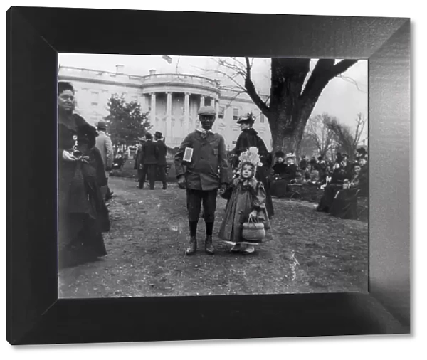 D.C. Wash. - White House - Negro boy holding hand of small white girl during Easter egg roll, 1898. Creator: Frances Benjamin Johnston