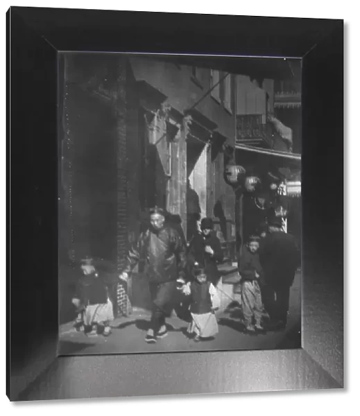 Man and two boys walking along a street, Chinatown, San Francisco, between 1896 and 1906. Creator: Arnold Genthe