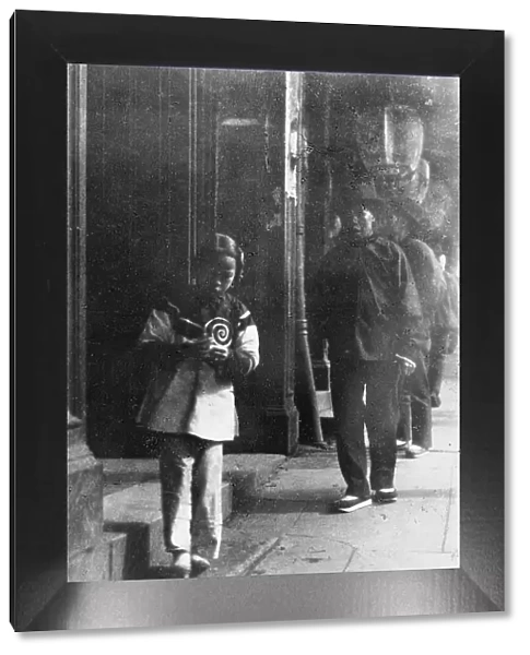 Young girl walking down a street, Chinatown, San Francisco, between 1896 and 1906. Creator: Arnold Genthe