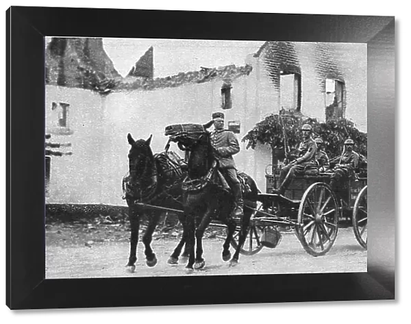 Des equipages allemands traversent, pres de Vise, le village de Mouland incendie, 1914. Creator: Vereenigde Fotobureaux Amsterdam