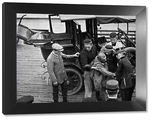 a Ostende des Belges consacrent d'infinies precautions au transport d'un blesse allemand, 1914. Creator: Unknown
