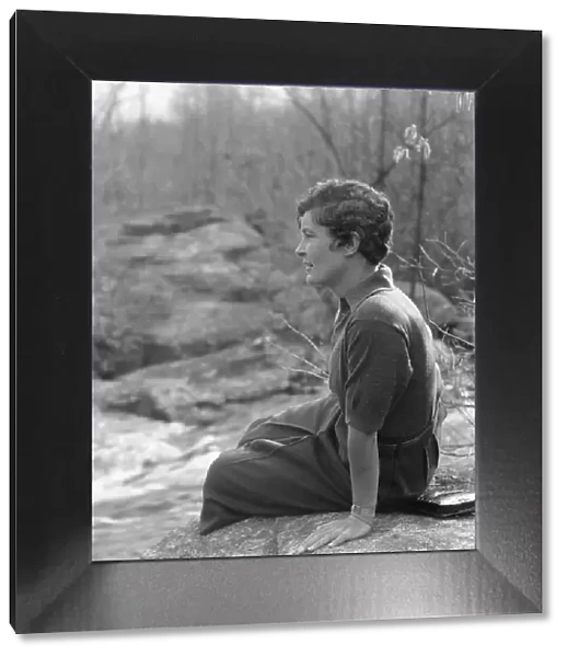 DeLamar, Alice, Miss, seated on a rock, between 1927 and 1942. Creator: Arnold Genthe