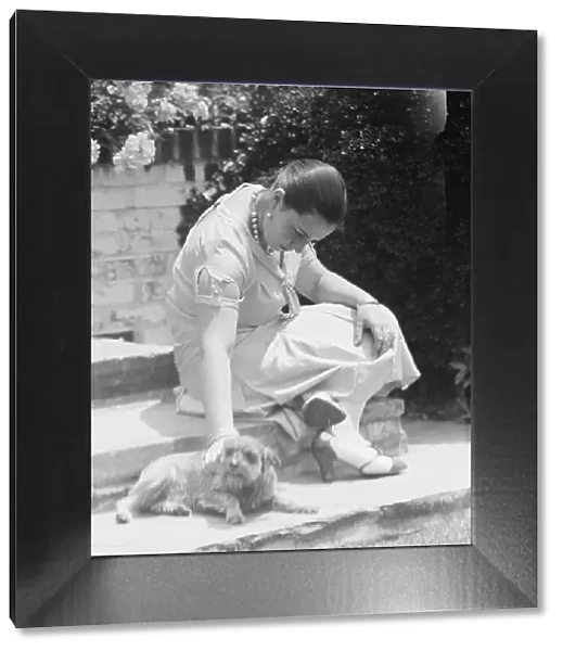 Manship, Pauline, Miss, with dog, seated outdoors, 1931 June 14. Creator: Arnold Genthe
