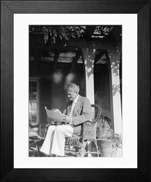 Framed Print : Arnold Genthe seated outdoors in a wicker chair reading, between 1911 and 1942. Creator: Arnold Genthe Framed Print : Arnold Genthe seated outdoors in a wicker chair reading, between 1911 and 1942. Creator: Arnold Genthe