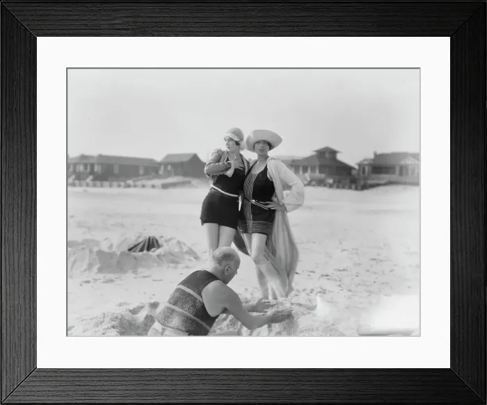 Framed Print : Unidentified man building sand castle and two women, Long Beach, New York, between 1911 and 1942. Creator: Arnold Genthe