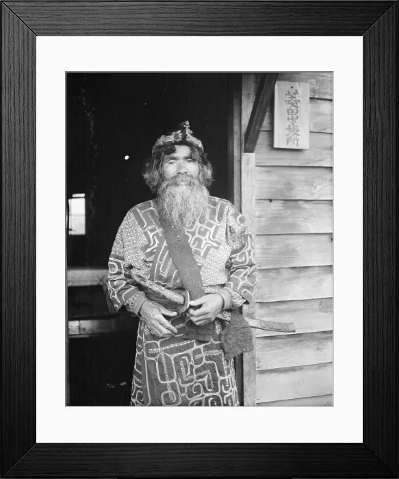 Framed Print : Ainu chief wearing a headdress and holding a sword standing in a doorway, 1908. Creator: Arnold Genthe Framed Print : Ainu chief wearing a headdress and holding a sword standing in a doorway, 1908. Creator: Arnold Genthe