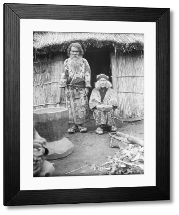 Framed Print : Ainu man and seated woman at the entrance of a hut, 1908. Creator: Arnold Genthe Framed Print : Ainu man and seated woman at the entrance of a hut, 1908. Creator: Arnold Genthe