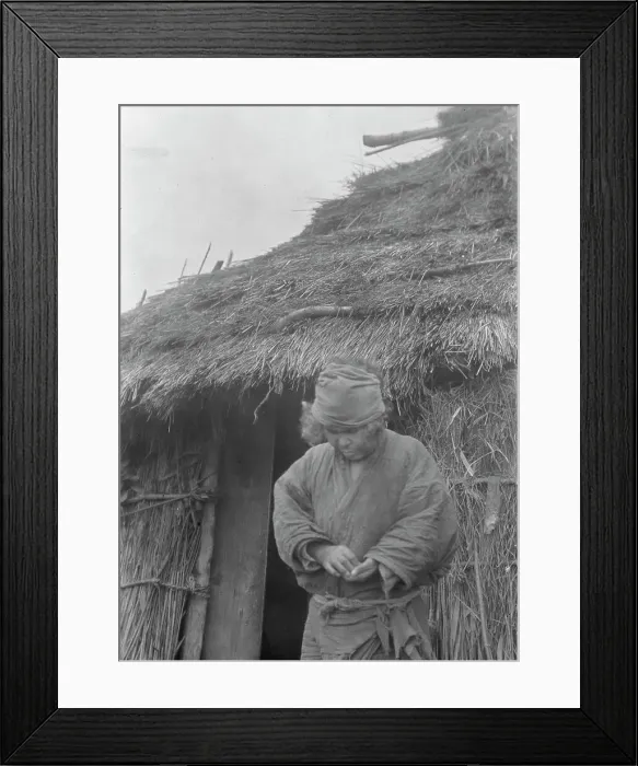 Framed Print : Ainu woman outside a hut, 1908. Creator: Arnold Genthe Framed Print : Ainu woman outside a hut, 1908. Creator: Arnold Genthe