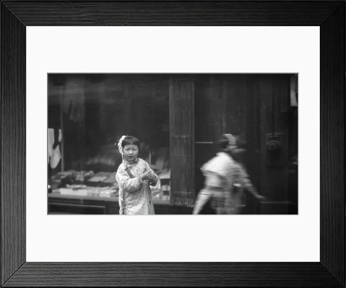 Framed Print : Young girl walking down the street, looking into the camera, Chinatown, San Francisco, c1896-1906. Creator: Arnold Genthe Framed Print : Young girl walking down the street, looking into the camera, Chinatown, San Francisco, c1896-1906. Creator: Arnold Genthe
