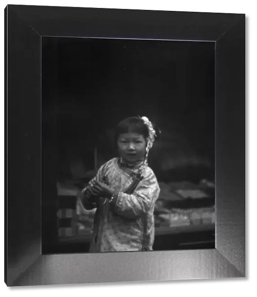 Young girl walking down the street, looking into the camera, Chinatown, San Francisco, c1896-c1906. Creator: Arnold Genthe