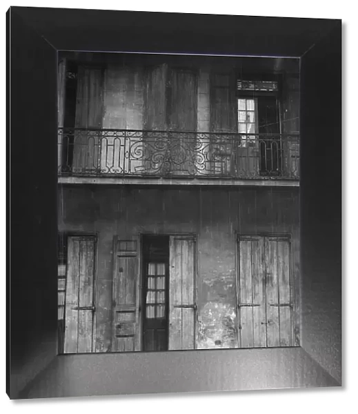Facade of a building with shuttered doors and balcony, New Orleans or Charleston... c1920-1926. Creator: Arnold Genthe