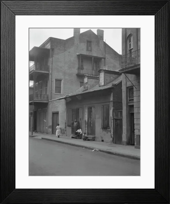 Framed Print : View from across street of a man and child sitting on steps and a woman walking down... c1920-1926. Creator: Arnold Genthe Framed Print : View from across street of a man and child sitting on steps and a woman walking down... c1920-1926. Creator: Arnold Genthe