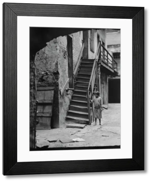 Framed Print : Child standing next to a stairway in a courtyard, New Orleans, between 1920 and 1926. Creator: Arnold Genthe Framed Print : Child standing next to a stairway in a courtyard, New Orleans, between 1920 and 1926. Creator: Arnold Genthe