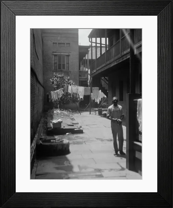 Framed Print : Man standing in a courtyard, New Orleans, between 1920 and 1926. Creator: Arnold Genthe Framed Print : Man standing in a courtyard, New Orleans, between 1920 and 1926. Creator: Arnold Genthe