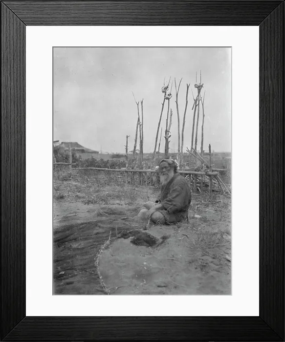 Framed Print : Seated Ainu man working on fishing nets, 1908. Creator: Arnold Genthe Framed Print : Seated Ainu man working on fishing nets, 1908. Creator: Arnold Genthe