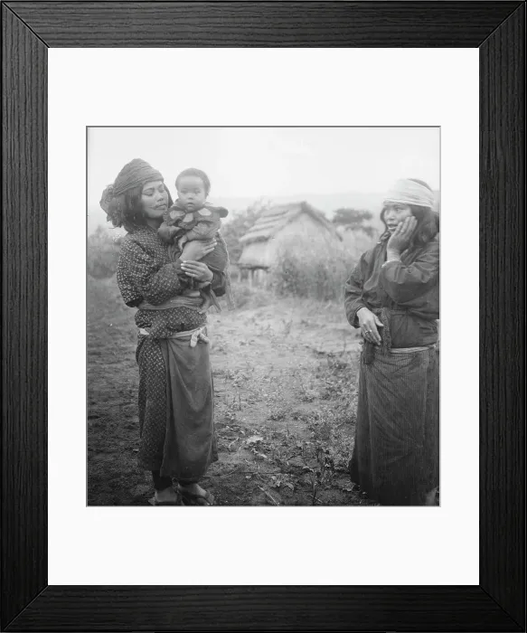 Framed Print : Two Ainu woman, one holding a child, standing outside, 1908. Creator: Arnold Genthe