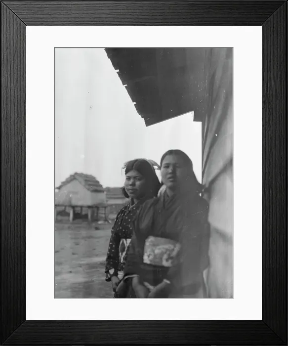 Framed Print : Two Ainu women standing outside by the wall of a wooden hut, 1908. Creator: Arnold Genthe Framed Print : Two Ainu women standing outside by the wall of a wooden hut, 1908. Creator: Arnold Genthe