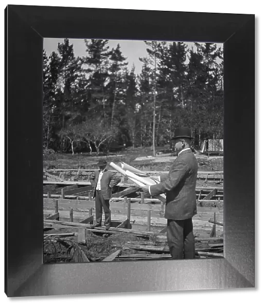 Unidentified man at a construction site studying building plans, between 1896 and 1942. Creator: Arnold Genthe