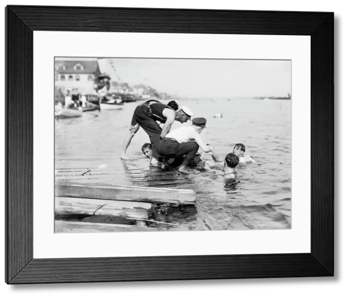 Framed Print : Untying Otto after 45 yd. swim - hands and feet tied, (1910?). Creator: Bain News Service Framed Print : Untying Otto after 45 yd. swim - hands and feet tied, (1910?). Creator: Bain News Service