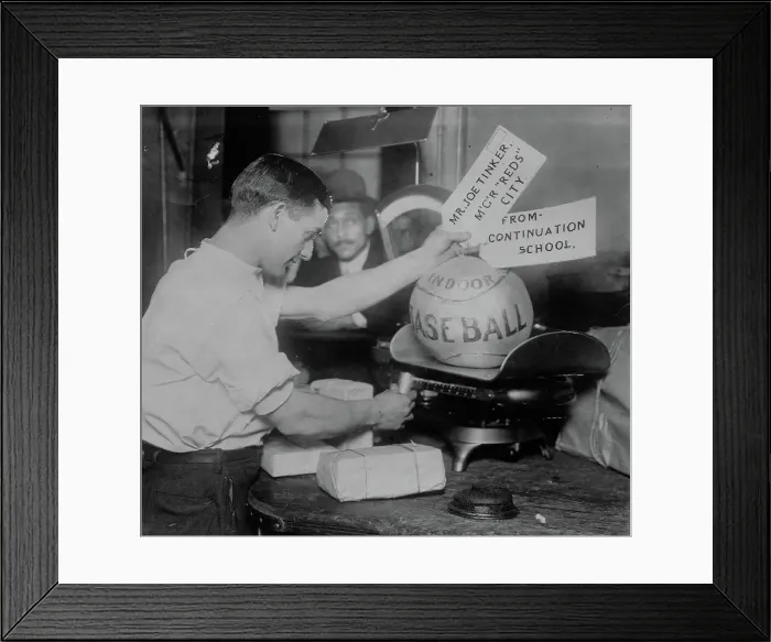 Framed Print : Medicine ball being weighed by Post Office employee; shipping tags read: Mr. Joe Tinker... 1913. Creator: Bain News Service
