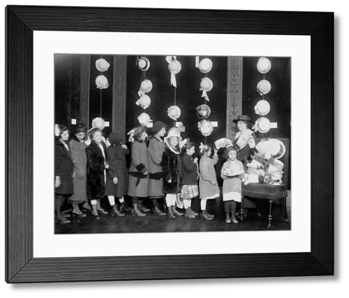 Framed Print : Natalie Stewart Distributing hats to poor children, between c1915 and c1920. Creator: Bain News Service Framed Print : Natalie Stewart Distributing hats to poor children, between c1915 and c1920. Creator: Bain News Service
