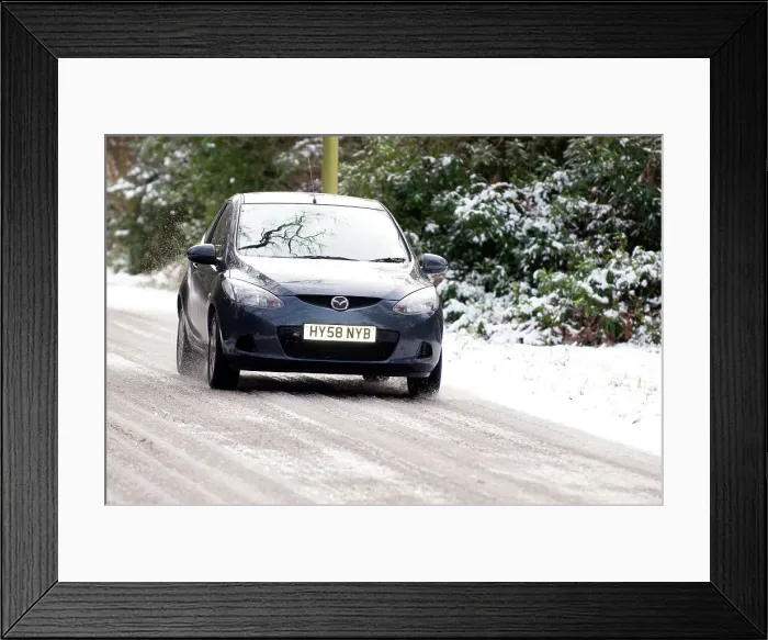 Framed Print : 2009 Mazda 2 driving on snowy road Framed Print : 2009 Mazda 2 driving on snowy road
