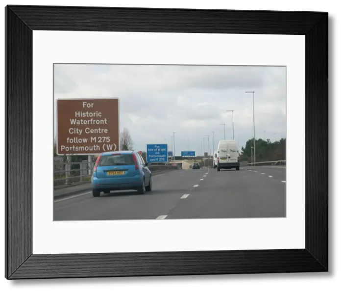 Framed Print : Traffic on M27 Motorway with brown tourist information sign Framed Print : Traffic on M27 Motorway with brown tourist information sign