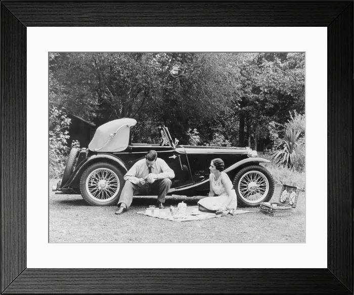 Framed Print : Couple having a picnic by an MG TA Midget, late 1930s Framed Print : Couple having a picnic by an MG TA Midget, late 1930s