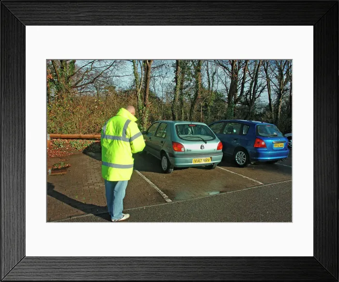 Framed Print : Car Park attendant recording car registration numbers Framed Print : Car Park attendant recording car registration numbers