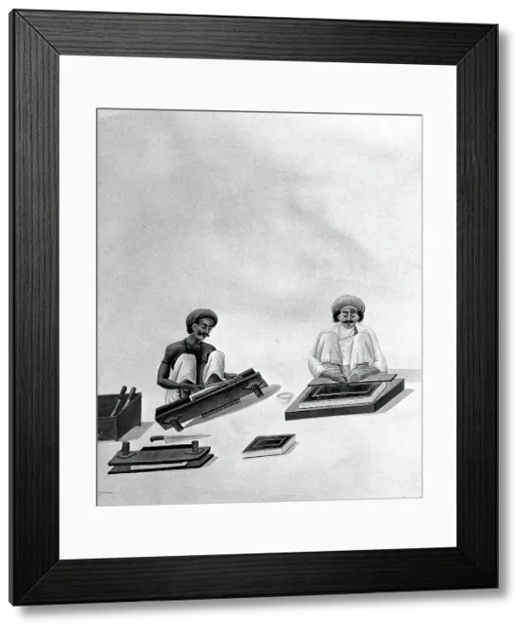 Framed Print : Two Indian bookbinders: one trimming page edges in a press, the other decorating a binding. Creator: Unknown